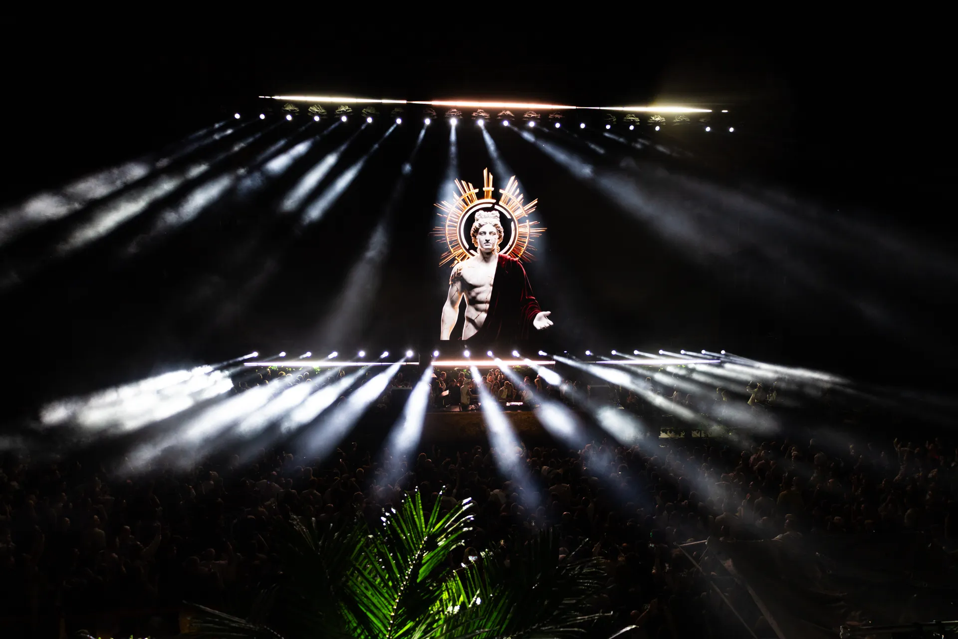Awakening of Eras — statue in beams of light over the crowd